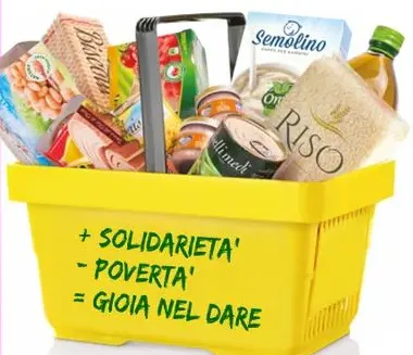 Una cesta gialla piena di alimenti: pasta, riso, olio, scatolame